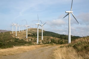 A line of wind turbines stretching across open countryside