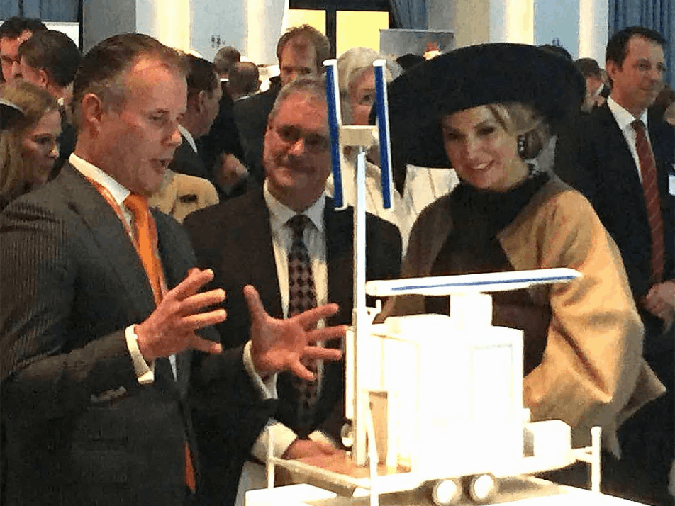 Queen Maxima and Robin Radar staff look at a radar detection prototype